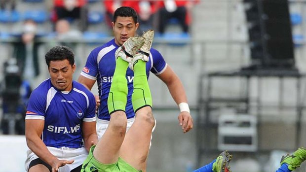 Desperate defence ... Ed Jenkins tackles Afa Aiono of Samoa in the final.