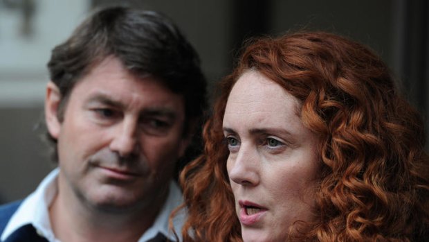 In the firing line: Rebekah Brooks and her husband Charlie address the media outside their lawyer's office.