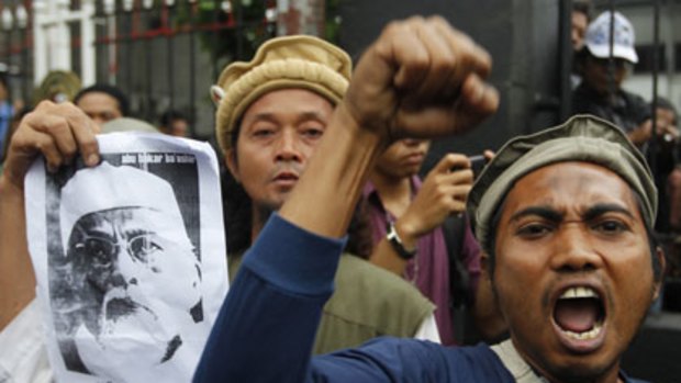 Show of strength ... Bashir supporters shout slogans outside court yesterday, despite being heavily outnumbered by police.