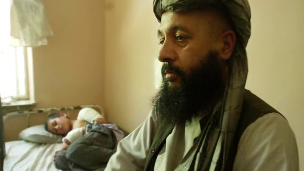 Lawmaker Abdul Khaliq with his injured son, Mohammed Yousaf, 9, at the Kandahar Hospital in southern Afghanistan in July 2006. The attack also killed his brother-in-law, blinded his wife and wounded his daughter.