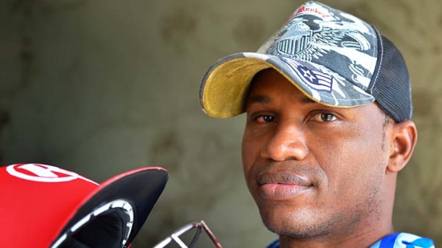 Marlon Samuels sports a swollen eye as he holds his bloodied helmet on Monday.