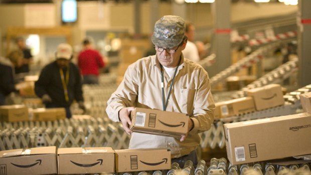 Sales surge: An Amazon.com employee removes items from a conveyor belt during the Christmas rush.