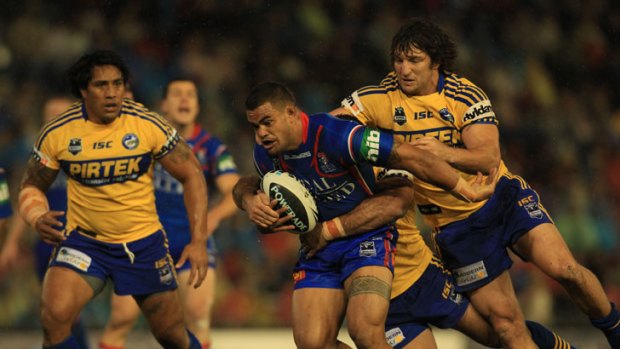 Richie Fa'aoso of the Knights is tackled by Nathan Hindmarsh.