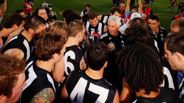 Collingwood players tune in to coach Mick Malthouse after the grand final ended in a draw on Saturday.