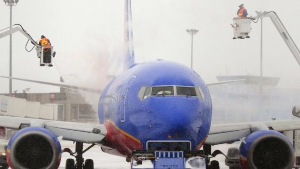 Flights resuming ... An ice crew sprays de-icing solution on a Southwest Airlines plane in Boston, Massachusetts.