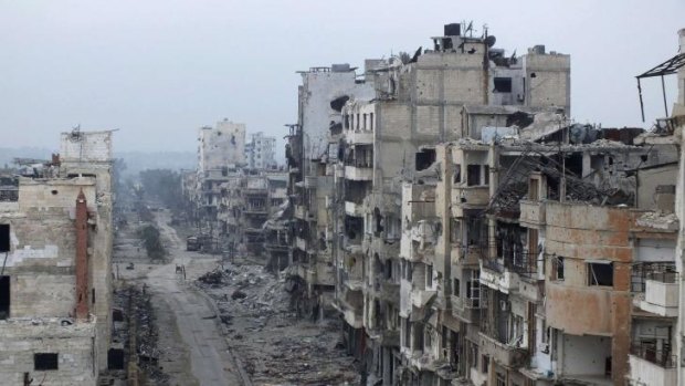 City of ruins: Damaged buildings line a street in the besieged area of Homs on Monday, January 27.