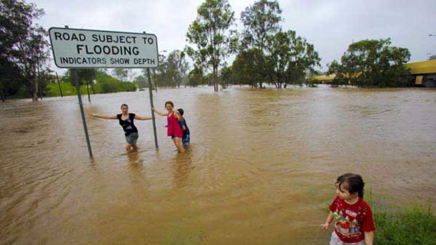 Children play in the rising Bremer River at Ipswich.