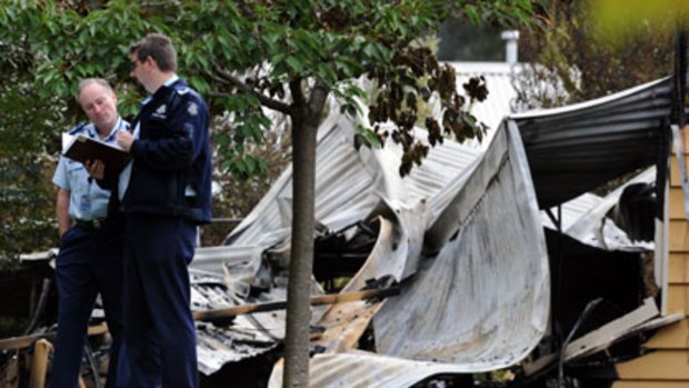 Authorities survey the scene of the fatal house fire at Mount Macedon.