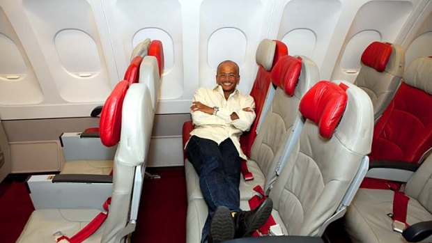 Stretching out a new revenue stream ... AirAsia X CEO, Azran Osman-Rani, lies across three seats.