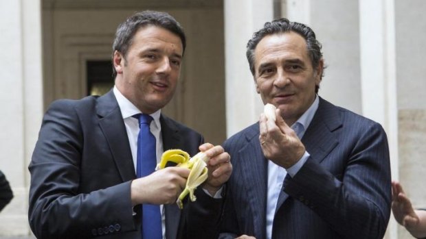 Italian premier Matteo Renzi, left, and Italian national soccer team coach Cesare Prandelli share a banana in solidarity to Barcelona Brazilian player Dani Alves.