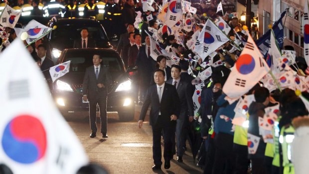 A vehicle carrying ousted South Korean President Park Geun-hye arrives through her supporters at her private home in Seoul.