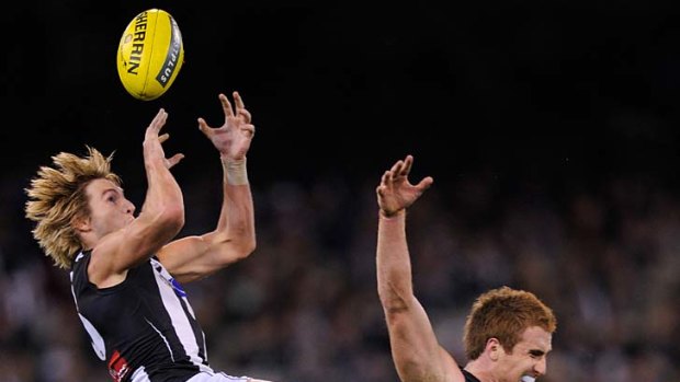 Magpie Dale Thomas flies high to take a juggled mark over Tiger Daniel Jackson on Friday night.