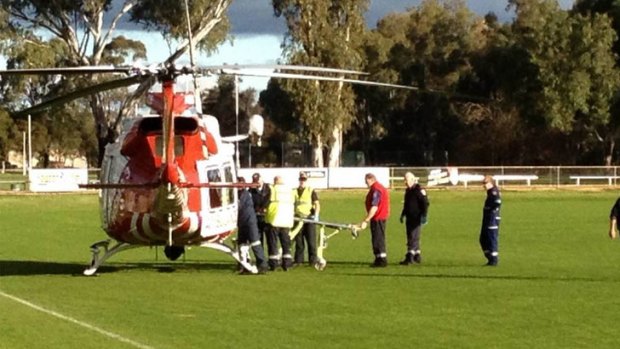 Paramedics load the second of the injured men into the air ambulance for transfer to Melbourne.