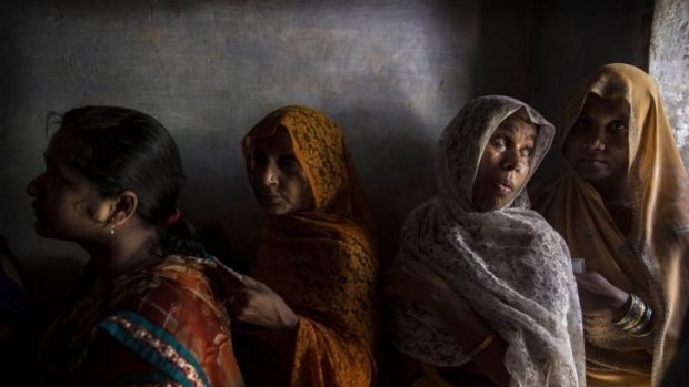 Women wait in line to vote at a polling station in Varanasi, India.