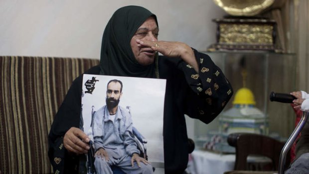 Samer Issawi's mother Layla holds his picture after the deal was announced.