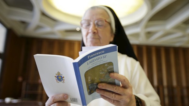 A nun reads Pope Francis' new encyclical titled 'Laudato si', the first papal document dedicated to the environment, at the Vatican on Thursday. 