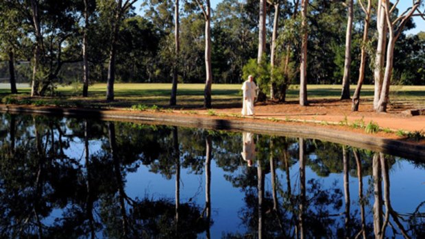 The Pope walks near a small lake at the Kenthurst Study Centre on the outskirts of  Sydney and (above)  with Cardinal George Pell and an unidentified bishop. Pictures: AP