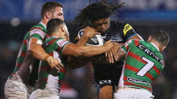 Wet and wild: Panthers centre Jamal Idris is stopped in his tracks by Adam Reynolds, Sam Burgess and Dylan Walker.
