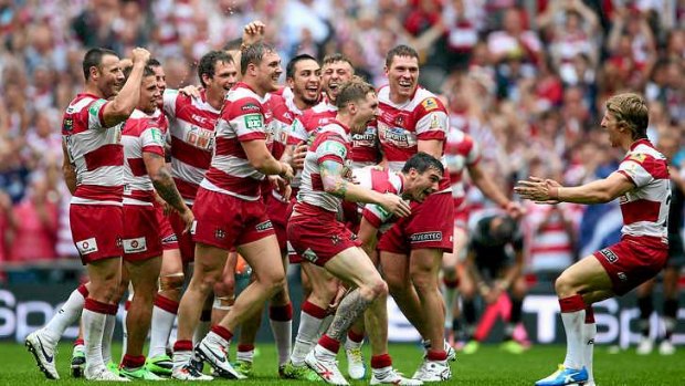 Wigan Warriors players celebrate winning the Challenge Cup final.