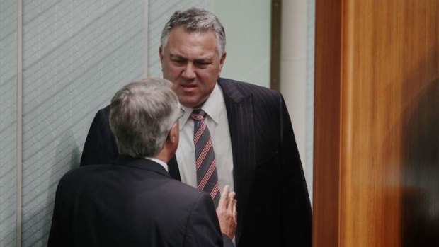 Acting Prime Minister Wayne Swan speaks with Shadow Treasurer Joe Hockey behind the Speaker's chair in Question Time.