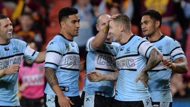 Before the fall: Teammates congratulate Todd Carney on a try against Brisbane on Friday night.