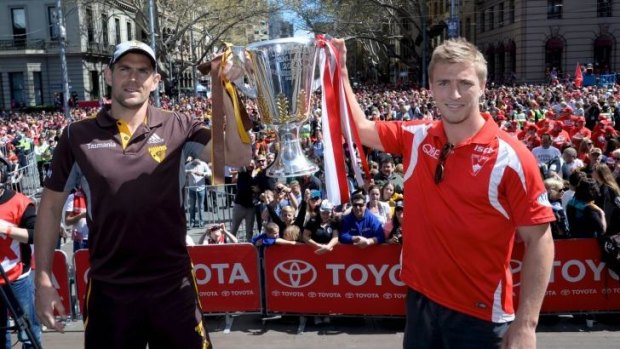 AFL captains Luke Hodge and Kieran Jack hold up the AFL premiership cup.