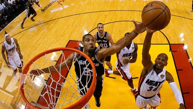 Tim Duncan of the San Antonio Spurs competes with Ray Allen, right, for a rebound.