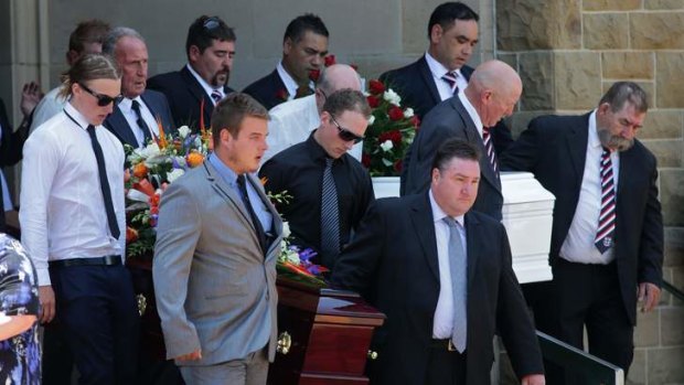 Pallbearers leave the packed church at the funeral.