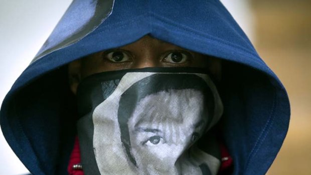 Global attention ... a man wears a hoodie and a scarf with the likeness of Trayvon Martin during a "One Thousand Hoodies March for Trayvon Martin" event at the University of Minnesota.
