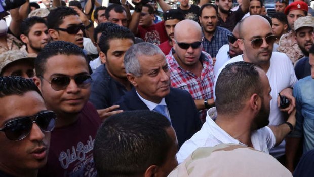 Libyan Prime Minister Ali Zeidan (centre) arrives at the government headquarters in Tripoli after he was freed.