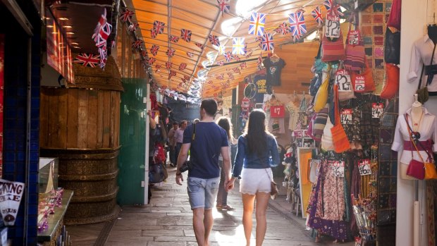 A couple wander through Camden Stables Market in London.