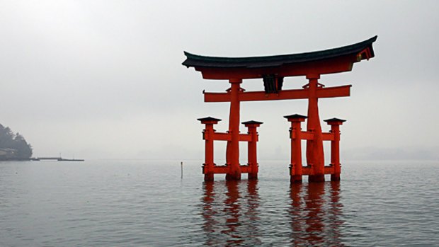 Holy site ... the revered O-torii Gate at Miyajima, the largest of its kind in Japan, stands amid the fog in tidal water.
