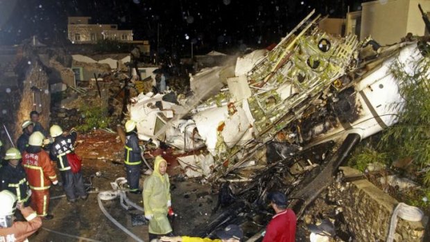 Rescue workers work next to the wreckage of TransAsia Airways flight GE222.