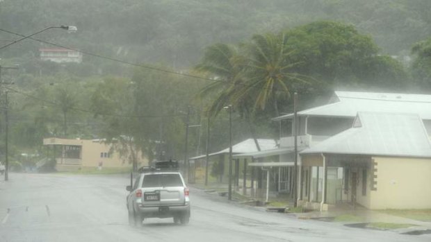 A car drives through torrential rain from Cyclone Ita