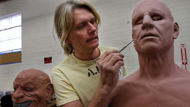 Lifelike ... Rusty Slusser adds skin pores into a form for one of his masks.