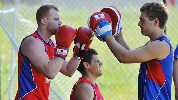 Hand in glove: Adam Cooney and Shaun Higgins enjoy a boxing session while Ryan Hargrave takes a breather during the Bulldogs' first pre-season training session.