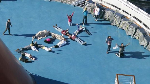 Passengers spell out the word "HELP" aboard the disabled Carnival Lines cruise ship Triumph as it is towed to harbour off Mobile Bay.