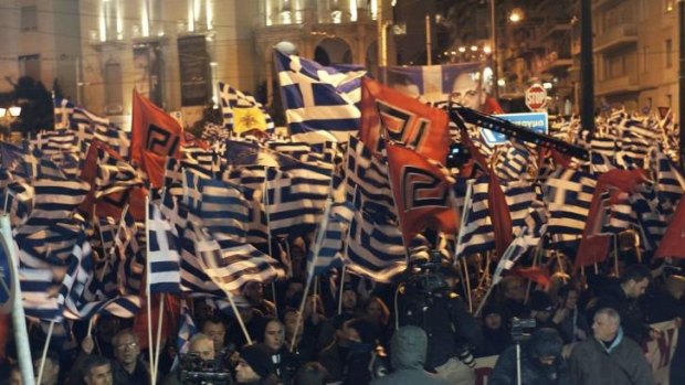 Rally: Thousands of Golden Dawn supporters carried Greek flags and the party's own flag, which uses a symbol that resembles a swastika. 