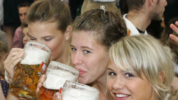 Girls in traditional Bavarian clothes toast at Oktoberfest in Munich.