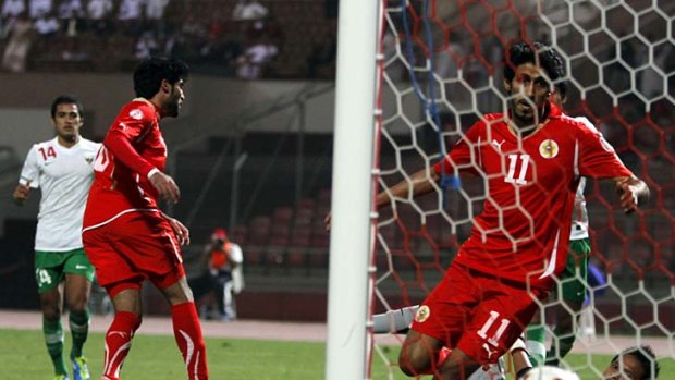 Bahrain's Abdullatif Ismaeel (11) watches the ball drift into the goal off a kick by his teammate Ali Mohamed (second left) during the game against Indonesia.