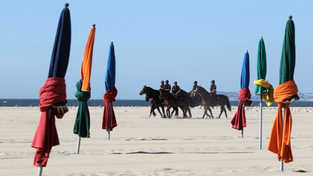Mounted police officers patrol a beach in Deauville, western France, as world leaders met for the G8 summit.