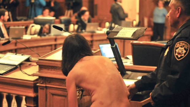 Unrestrained protest ... a women disrobes inside San Francisco's city hall after the ban on public nudity was approved.