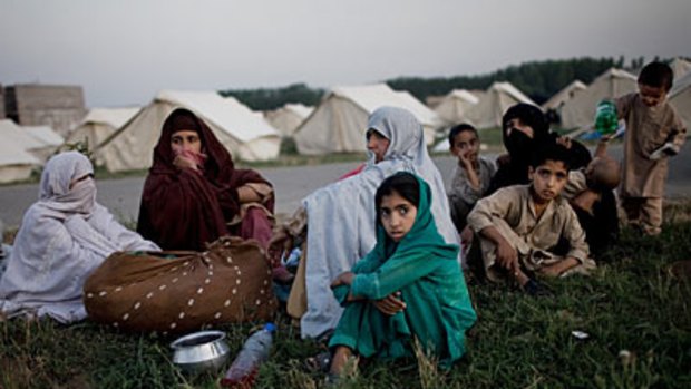 A long way from home... Pakistani children wait for water at the Jalala camp after fleeing fighting in the Swat Valley.