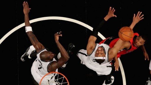 Toronto's Kyle Lowry competes for a rebound with taller Brooklyn duo Kevin Garnett and Paul Pierce.