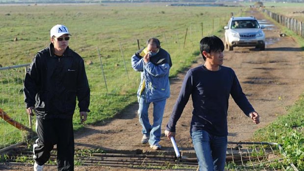Men leave the Rockbank property yesterday during the raid by the RSPCA and police to break up a cockfighting ring.
