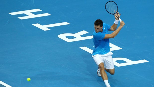 Bernard Tomic of Australia returns a backhand volley in his singles match against Tommy Haas of Germany.