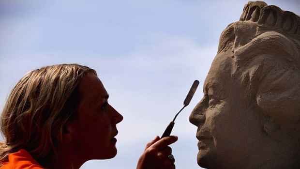 Touch up &#8230; artist Nicola Wood sculpts the Queen in sand.