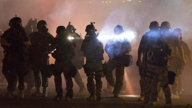 Riot police clear demonstrators from a street in Ferguson, Missouri.