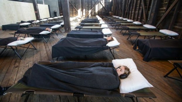 In another Marina Abramovic event, participants are tucked into bed in what feels like an austere school camp.