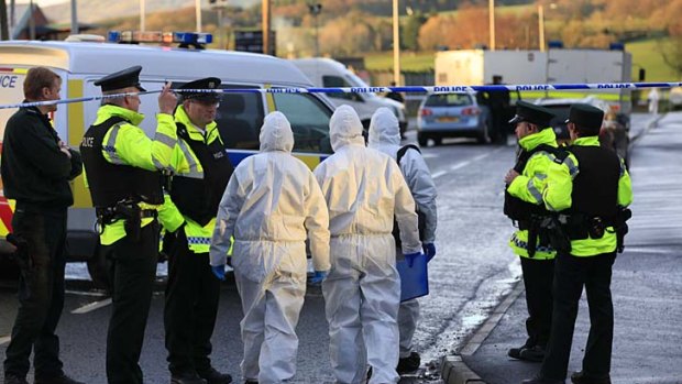 Tragedy ... forensic police officers at the scene of the car bombing.